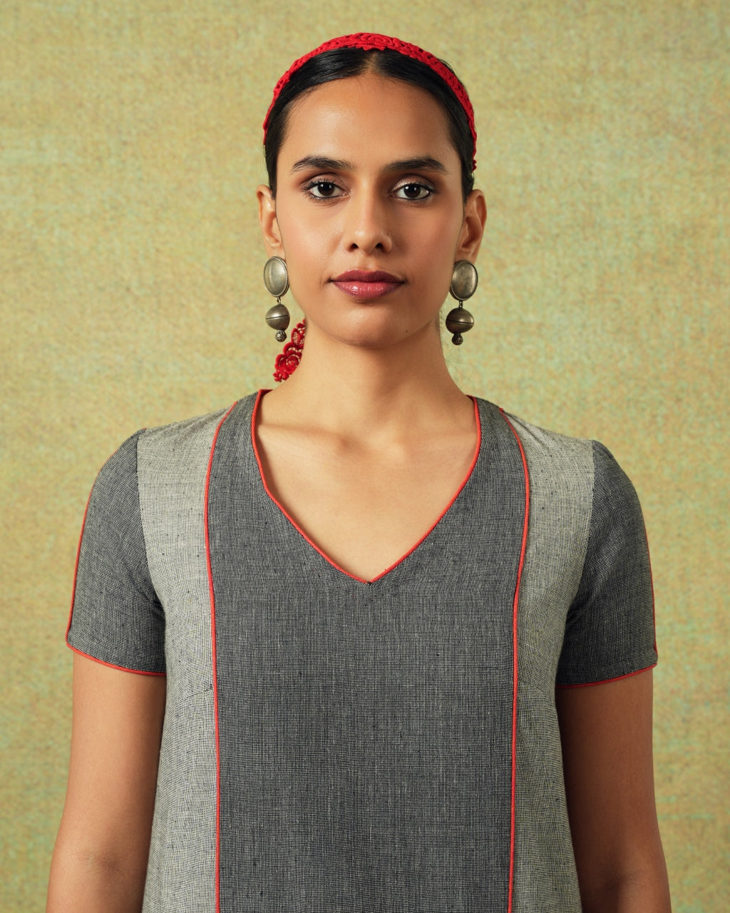 Close up of the V-neck line of Patchwork dress in shades of grey with bold orange side pocket – RA Studio