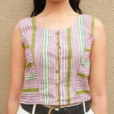Woman wearing a sleeveless striped shirt with a beige background
