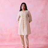 Beige cotton Mangalgiri co-ord with a front-pleated button kurta and contrast top stitching on the kurta and pant hems.