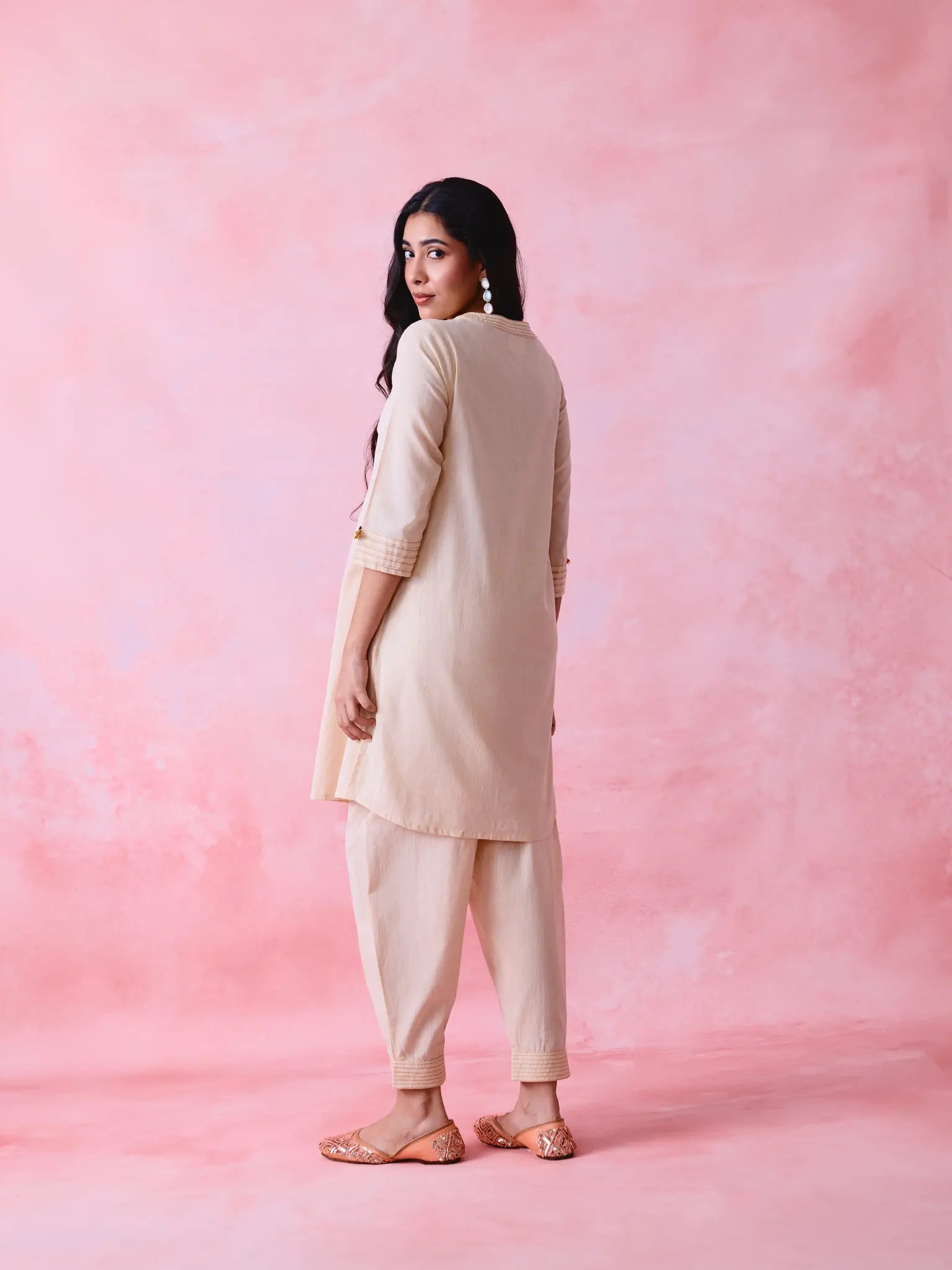 Beige cotton Mangalgiri co-ord with a front-pleated button kurta and contrast top stitching on the kurta and pant hems.