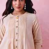 Beige cotton Mangalgiri co-ord with a front-pleated button kurta and contrast top stitching on the kurta and pant hems.