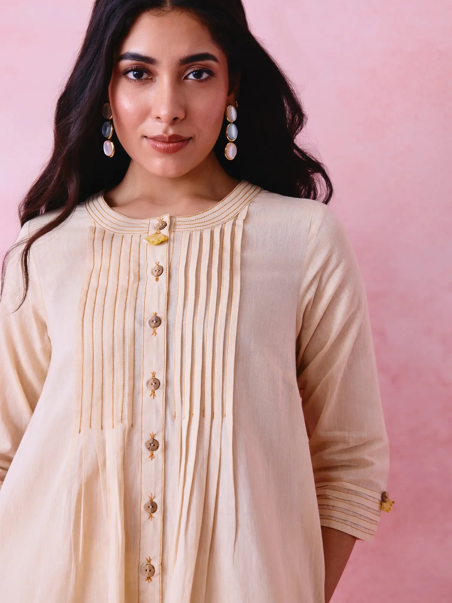 Beige cotton Mangalgiri co-ord with a front-pleated button kurta and contrast top stitching on the kurta and pant hems.
