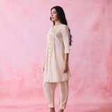 Beige cotton Mangalgiri co-ord with a front-pleated button kurta and contrast top stitching on the kurta and pant hems.