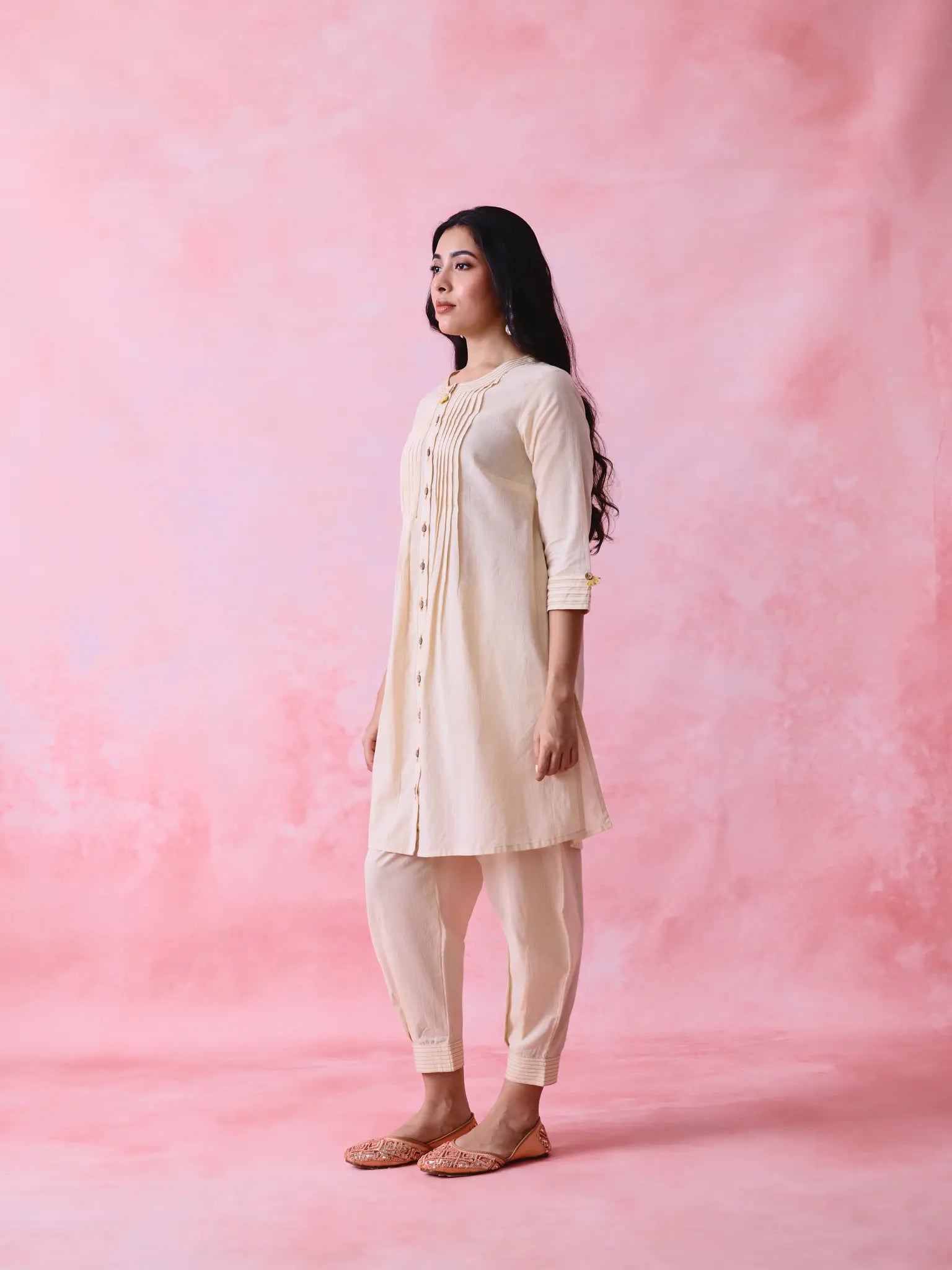 Beige cotton Mangalgiri co-ord with a front-pleated button kurta and contrast top stitching on the kurta and pant hems.