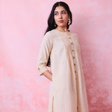 Beige cotton Mangalgiri co-ord with a front-pleated button kurta and contrast top stitching on the kurta and pant hems.