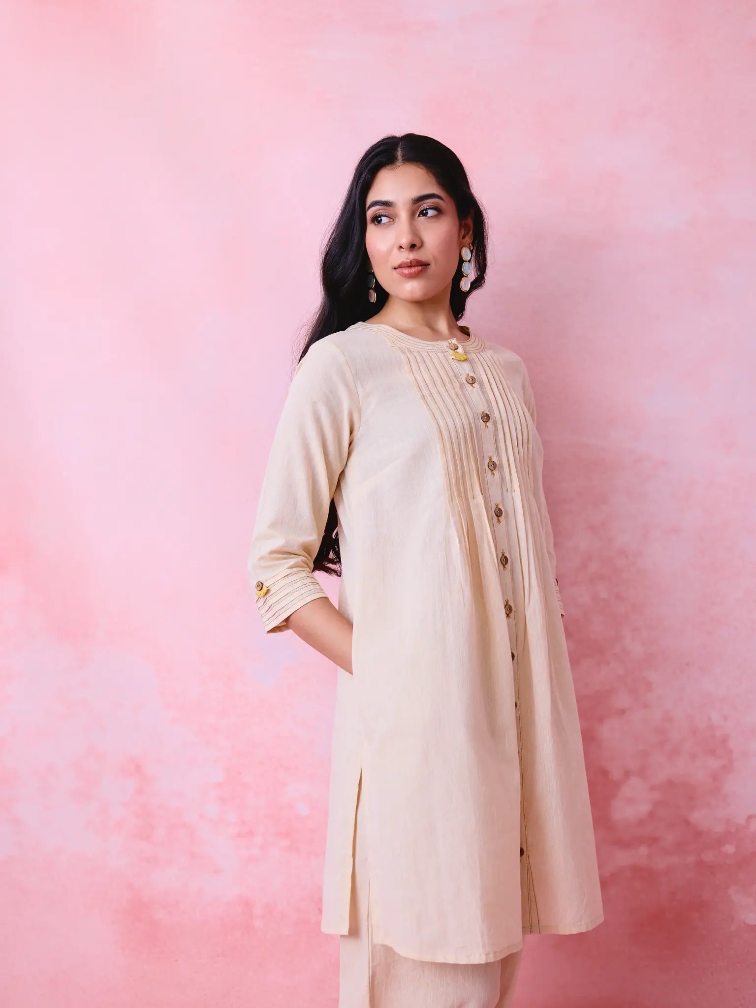 Beige cotton Mangalgiri co-ord with a front-pleated button kurta and contrast top stitching on the kurta and pant hems.