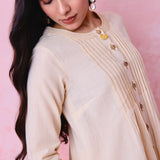 Beige cotton Mangalgiri co-ord with a front-pleated button kurta and contrast top stitching on the kurta and pant hems.