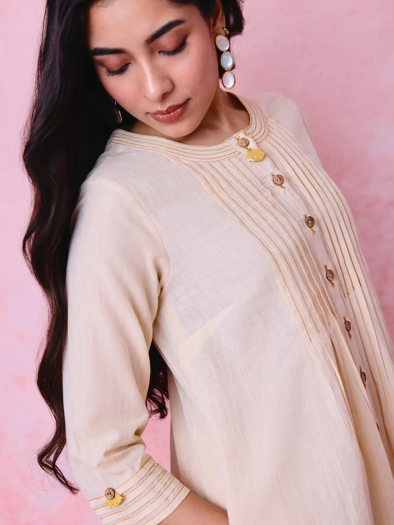 Beige cotton Mangalgiri co-ord with a front-pleated button kurta and contrast top stitching on the kurta and pant hems.