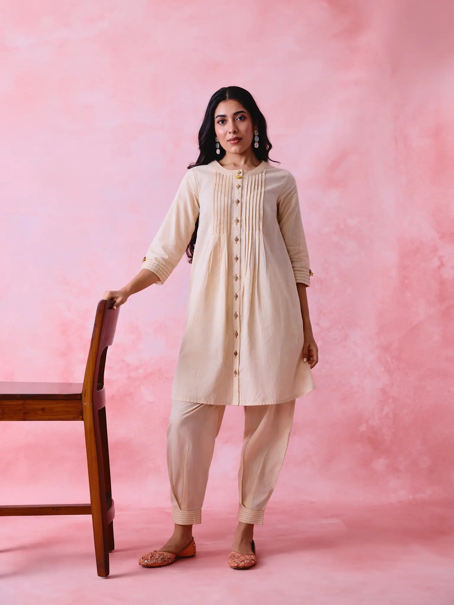 Beige cotton Mangalgiri co-ord with a front-pleated button kurta and contrast top stitching on the kurta and pant hems.
