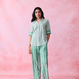 Green cotton co-ord with a thin-stripe block-print collared tunic shirt, turn-up sleeves and wide-stripe flared pants.