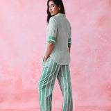 Green cotton co-ord with a thin-stripe block-print collared tunic shirt, turn-up sleeves and wide-stripe flared pants.