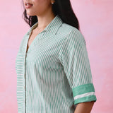 Green cotton co-ord with a thin-stripe block-print collared tunic shirt, turn-up sleeves and wide-stripe flared pants.