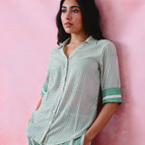 Green cotton co-ord with a thin-stripe block-print collared tunic shirt, turn-up sleeves and wide-stripe flared pants.