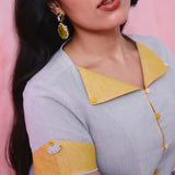 Grey cotton Mangalgiri kurta and straight-pant co-ord with a flap collar, loop buttons and mustard-yellow accents.