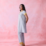 Grey cotton Mangalgiri kurta and straight-pant co-ord with a flap collar, loop buttons and mustard-yellow accents.