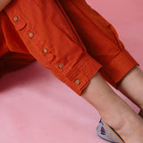 Red cotton Mangalgiri co-ord with a front-pleated, contrast-stitched kurta and button-and-cotton-bell pant hems.
