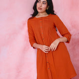Red cotton Mangalgiri co-ord with a front-pleated, contrast-stitched kurta and button-and-cotton-bell pant hems.