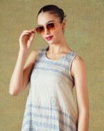Close up of Model wearing blue crinkled empire-line shift dress with layered block-print stripes and pockets – RA Studio